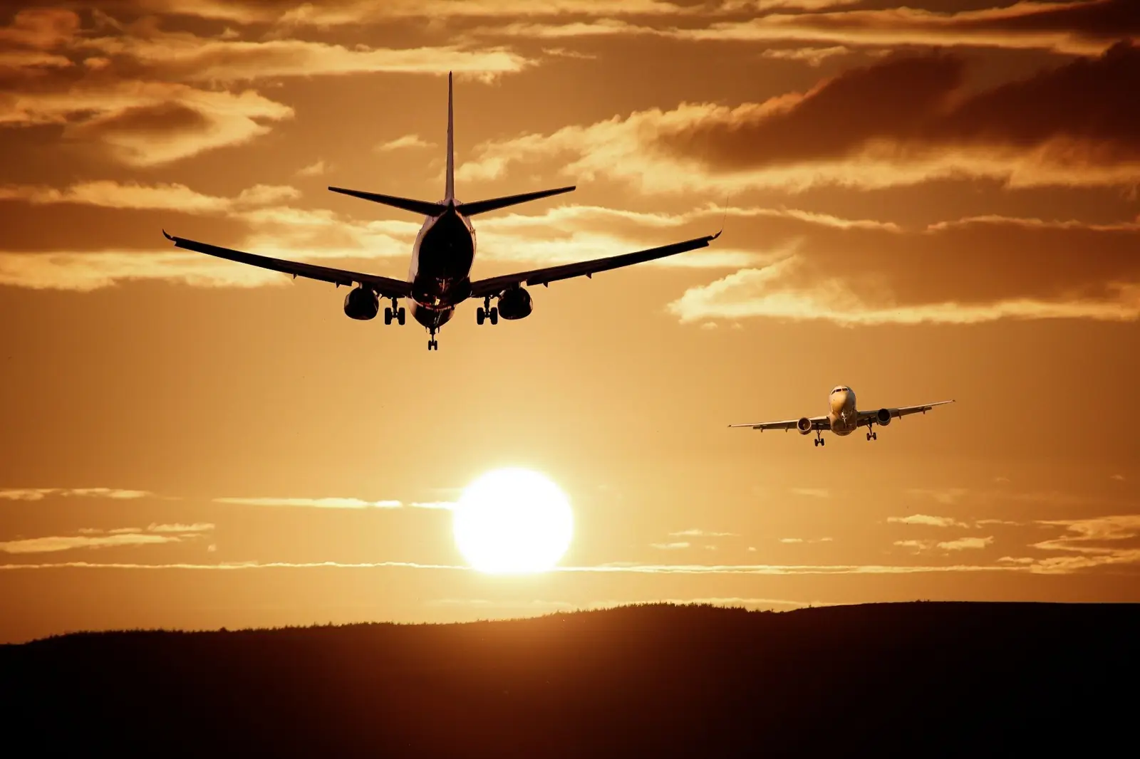 Two airliners landing at sunset